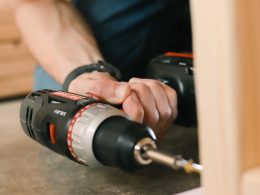 person holding black and red cordless hand drill