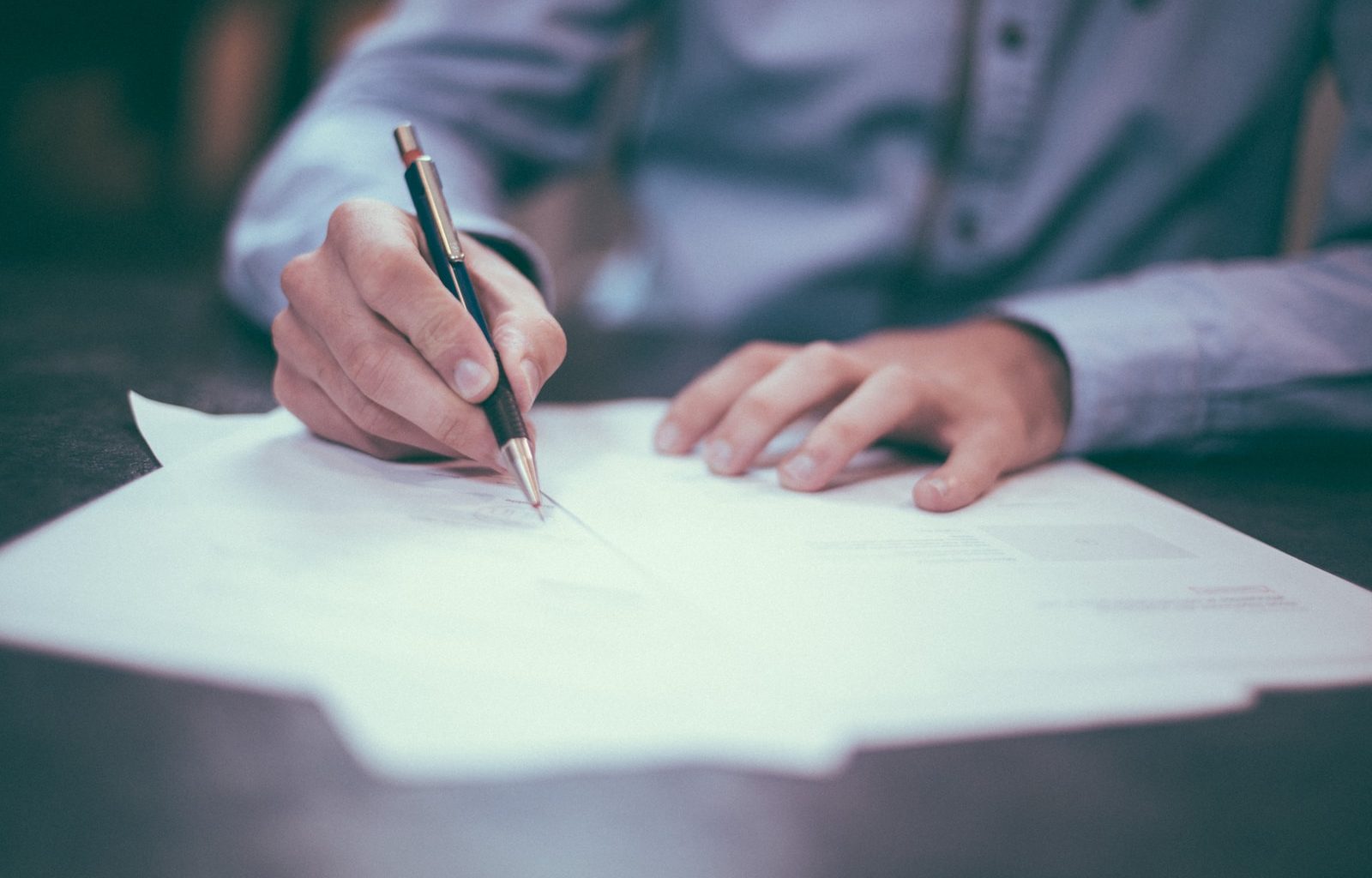 man writing on paper