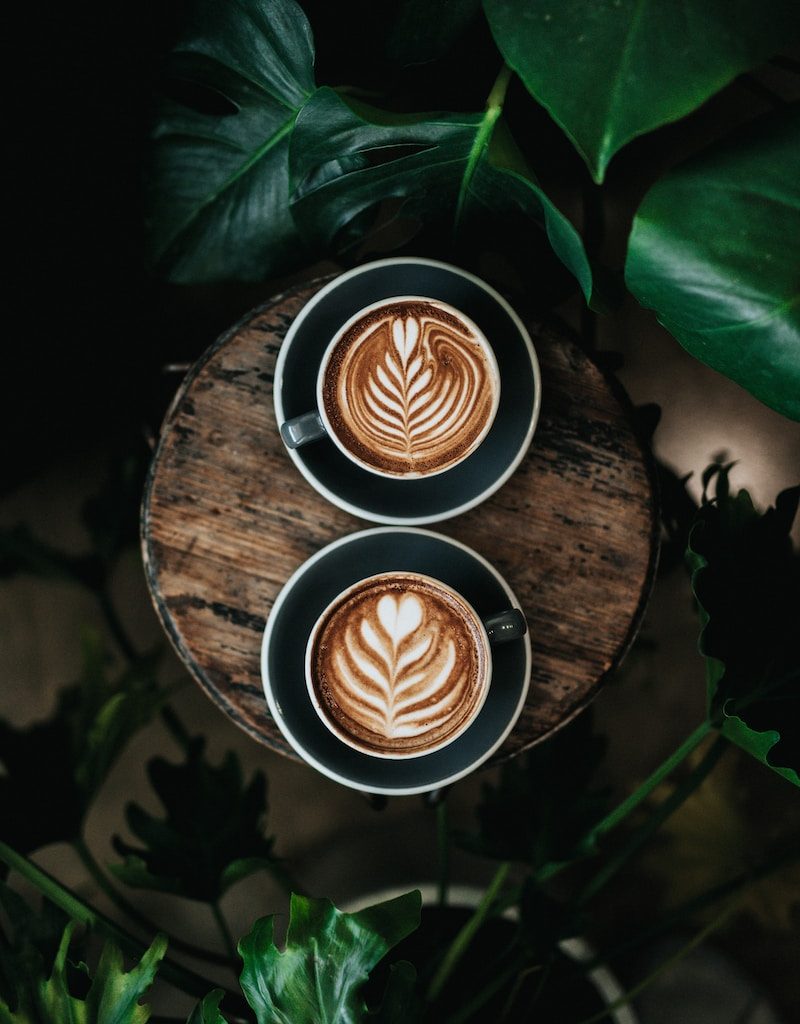 high angle photo of two green mugs filled with coffee