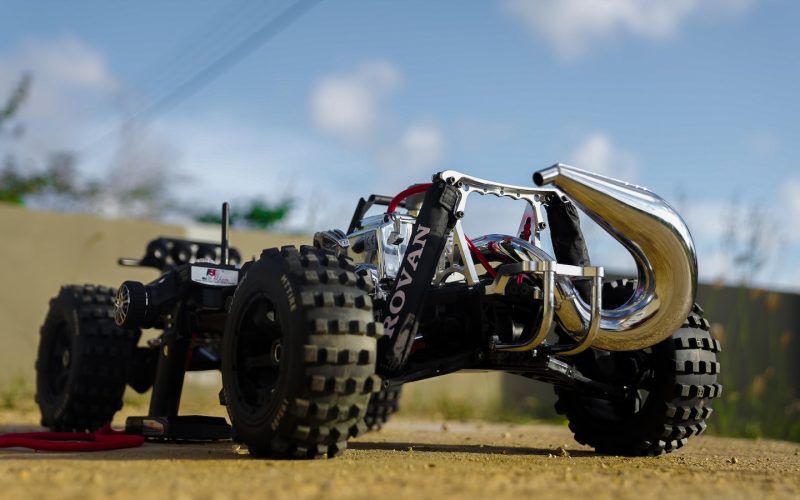 a toy truck with four wheels on a dirt road