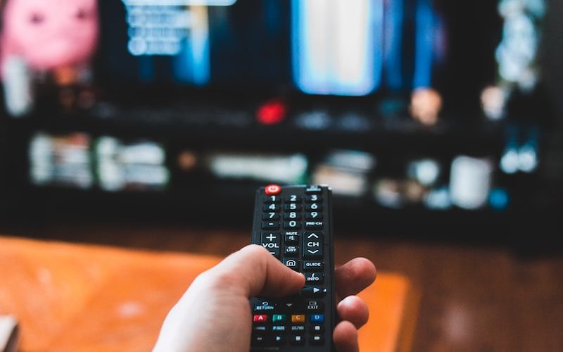 person holding black remote control