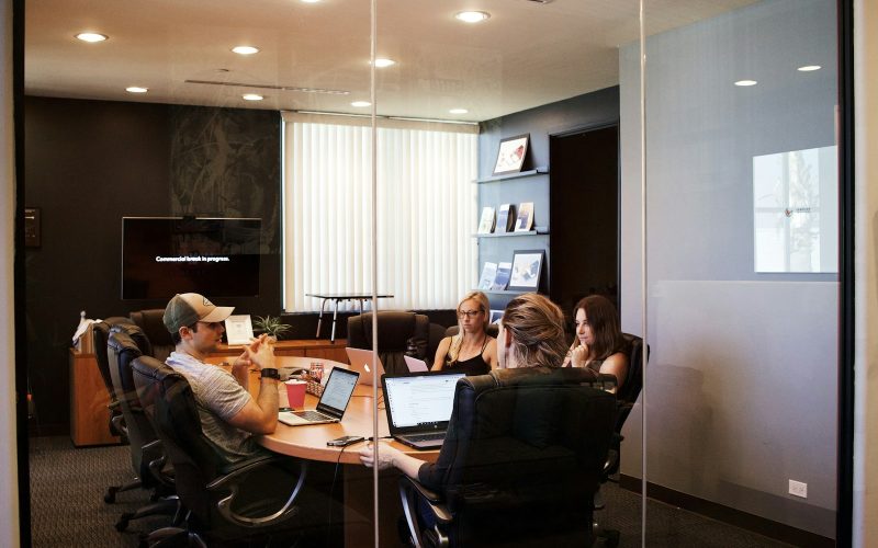 people sitting near table with laptop computer