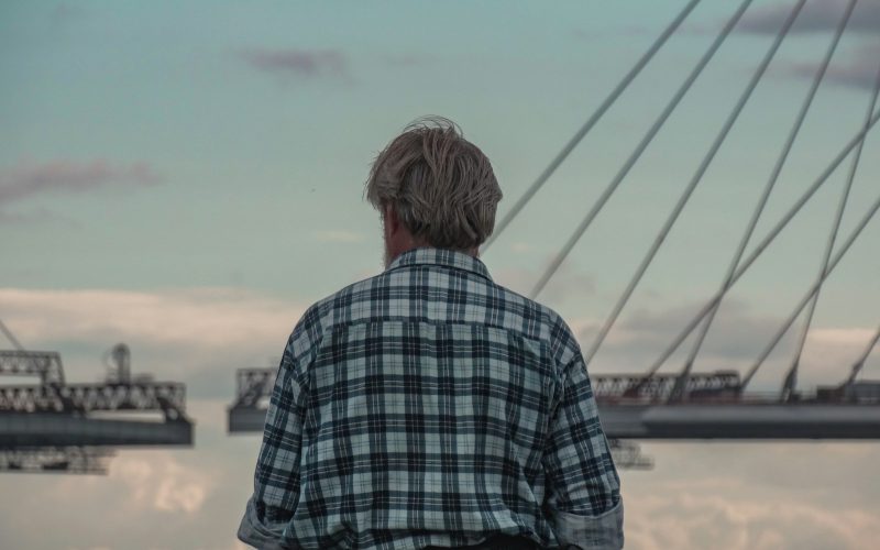 a man standing in front of a body of water