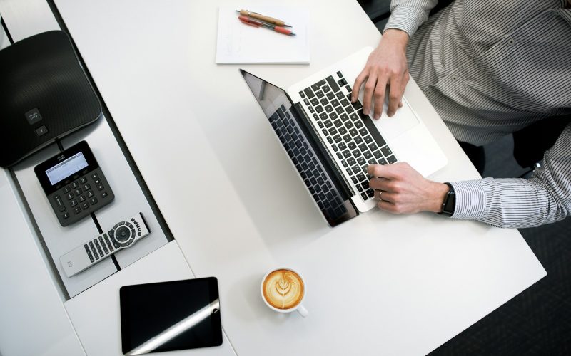 person using laptop on white wooden table