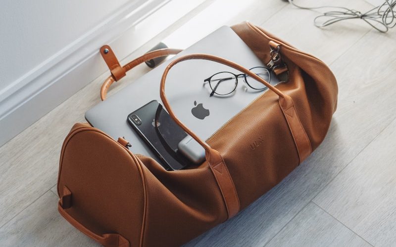 silver MacBook in duffel bag