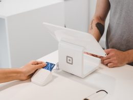 person using white tablet computer on table