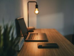 black laptop computer on brown wooden table