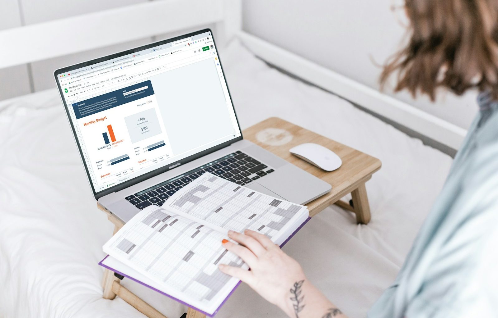 a person sitting on a bed with a laptop