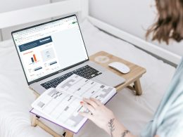 a person sitting on a bed with a laptop