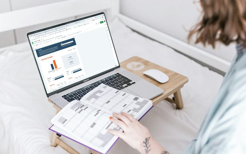 a person sitting on a bed with a laptop