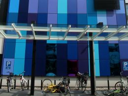 white and black city bikes parked beside blue and white building during daytime