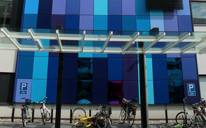 white and black city bikes parked beside blue and white building during daytime