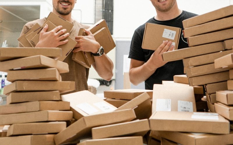 a couple of men standing next to a pile of boxes