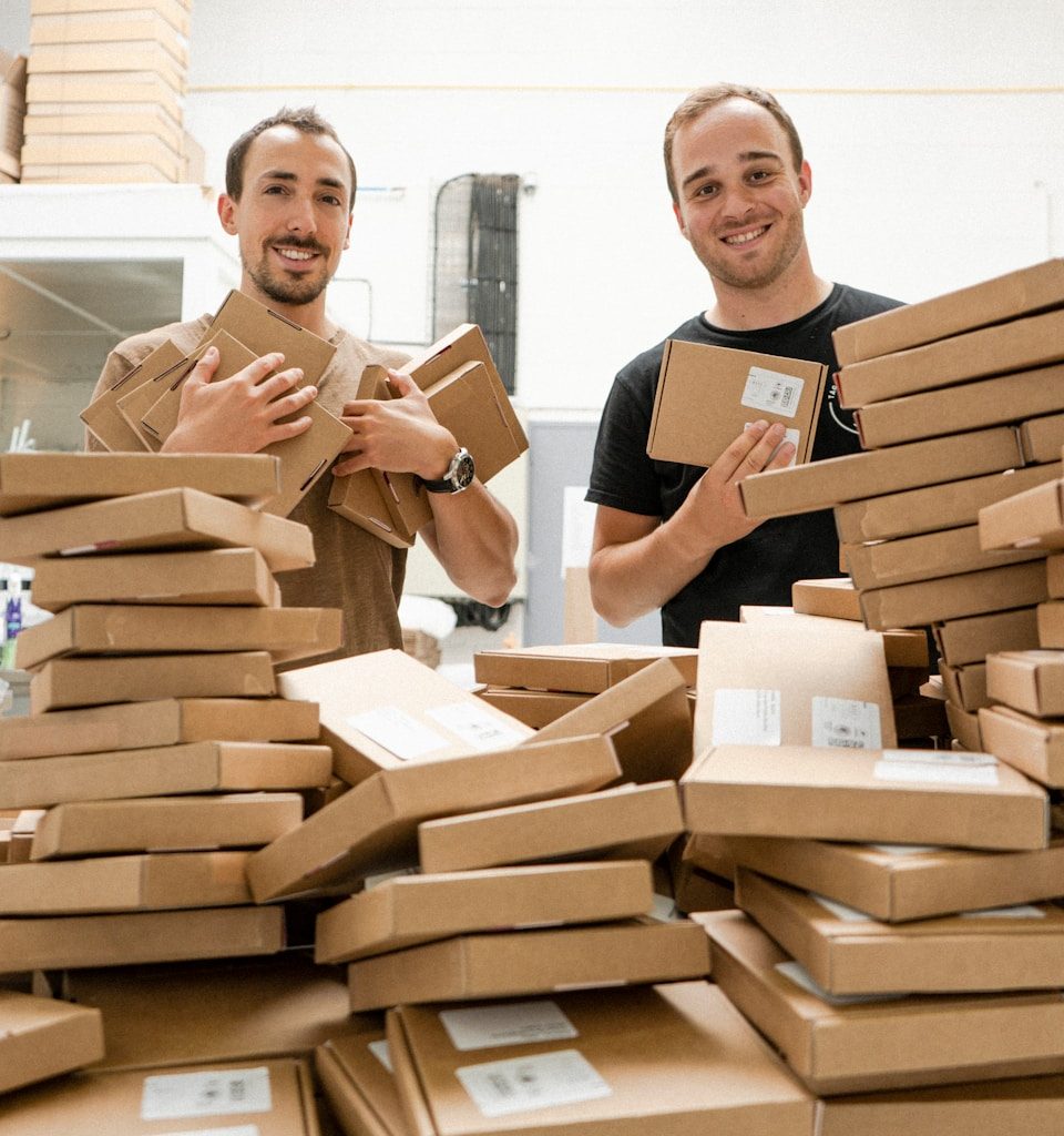 a couple of men standing next to a pile of boxes
