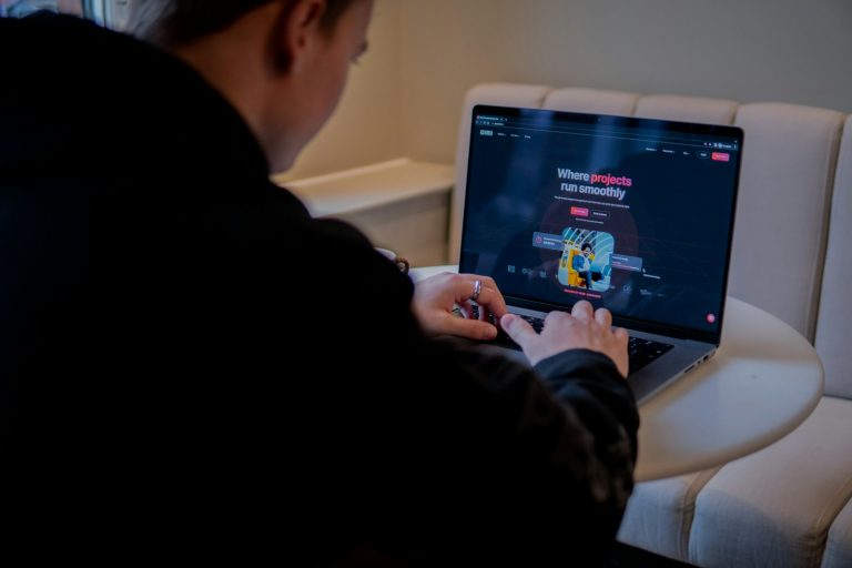 a person sitting at a table with a laptop