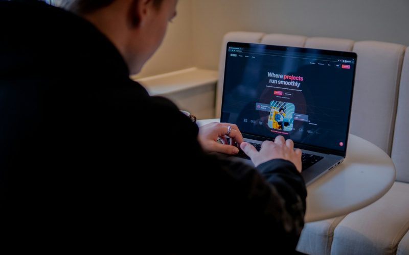 a person sitting at a table with a laptop
