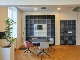 Bright and stylish office space with contemporary furniture and open shelving.