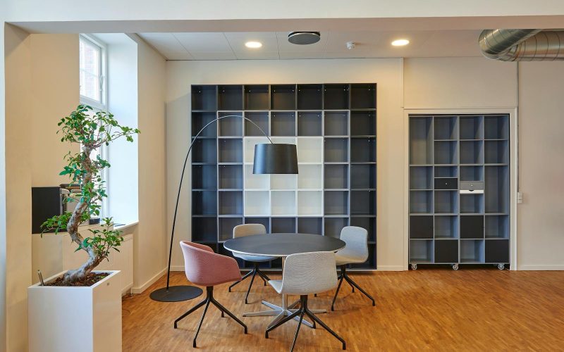 Bright and stylish office space with contemporary furniture and open shelving.