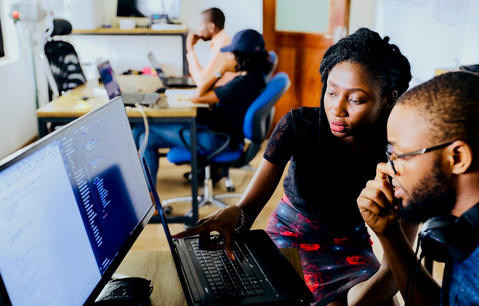 woman and man sitting in front of monitor
