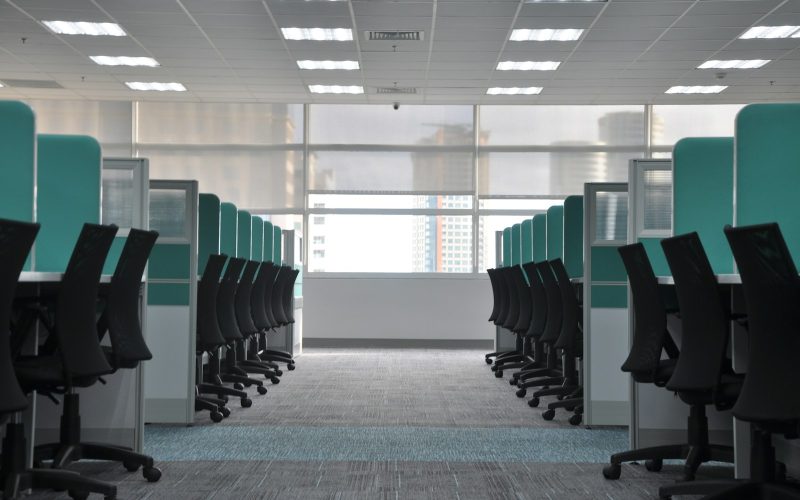 empty black rolling chairs at cubicles