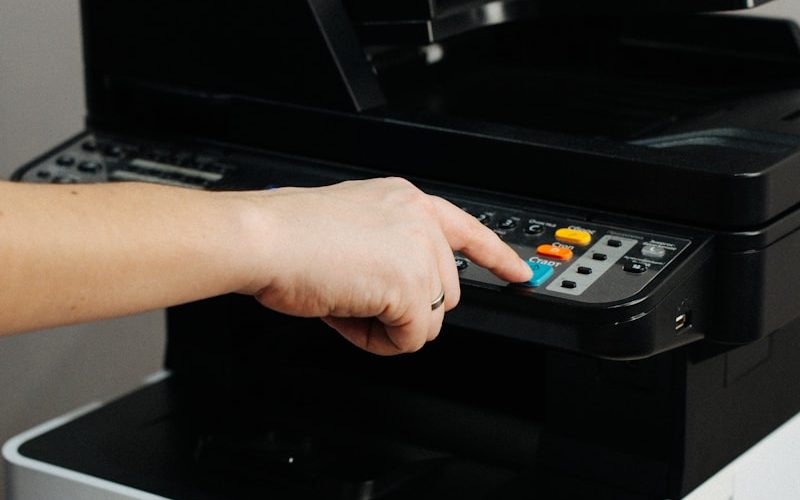 A person is pressing a button on a printer