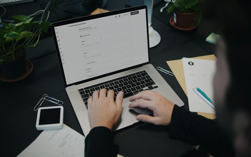 A person sitting at a desk using a laptop computer