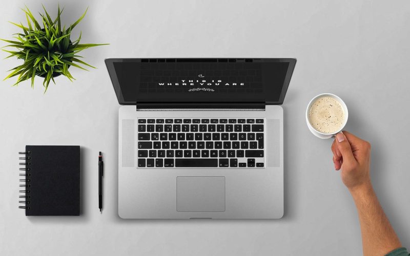 Medewerker die ergonomisch thuiswerkt achter een bureau met extern beeldscherm